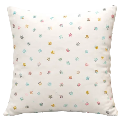 White pillow with scattered pastel paw prints